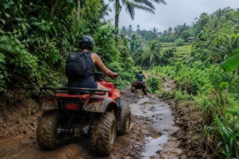 ATV rider navigating a muddy jungle trail in Bali