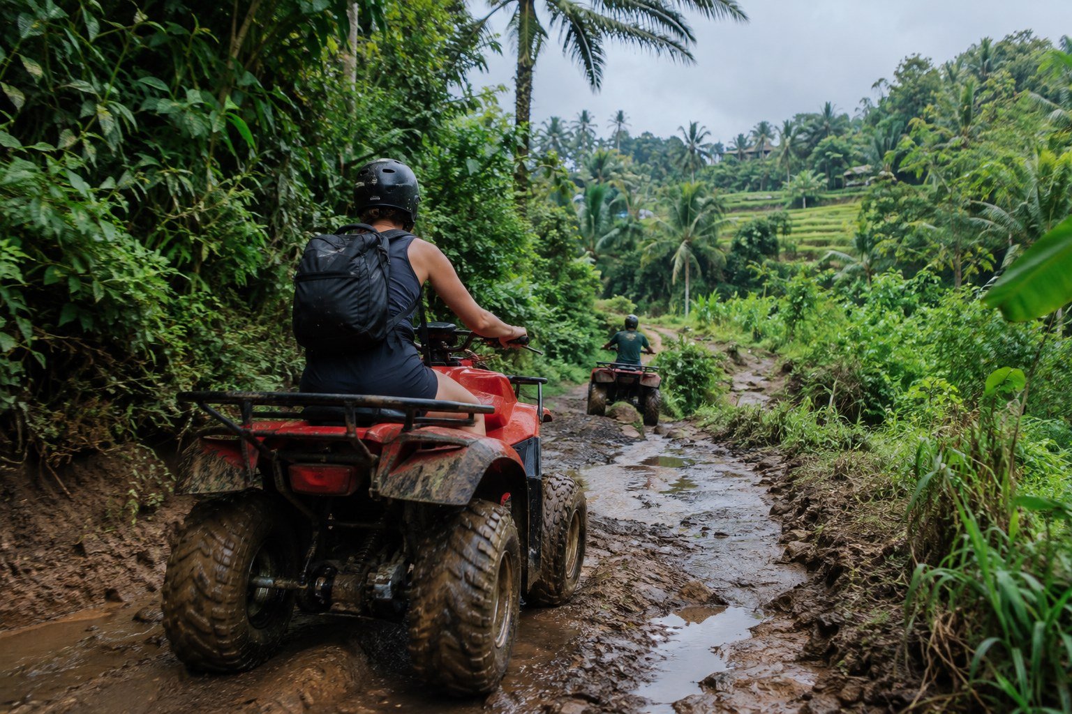 ATV rider navigating a muddy jungle trail in Bali