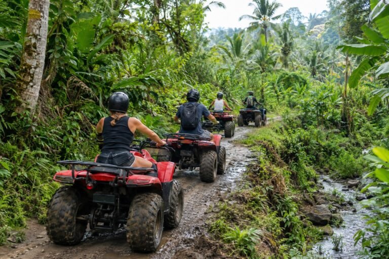 Beginners riding ATVs with a guide on a tropical Bali jungle trail
