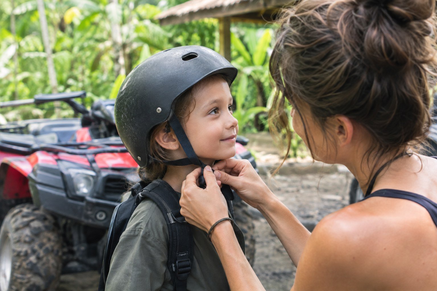 Parent checking a child's ATV helmet before riding in Bali