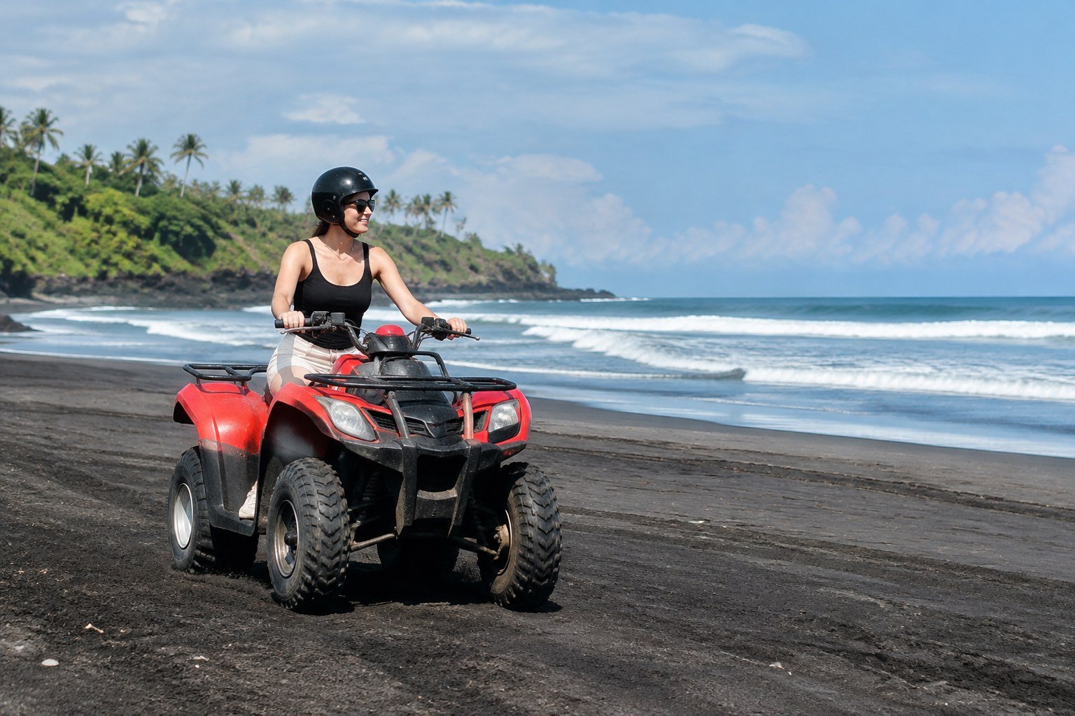 Tourist riding an ATV on a black volcanic sand beach in Bali